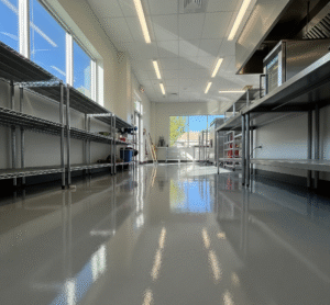 Light gray epoxy floor in a clean, well-lit commercial kitchen in Salt Lake City, Utah. by Hermetic Coatings